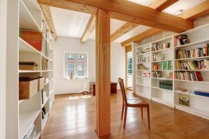 a room with bookshelves and a chair in a room at Ferienhaus im Vorwerk Nickern in Dresden