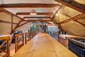 a long wooden table in a kitchen with wooden beams at Wohlfühlurlaub in der Scheune in Ochsensaal