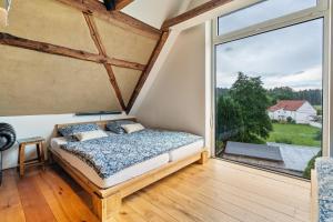 a bedroom with a bed and a large window at Wohlfühlurlaub in der Scheune in Ochsensaal