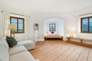 a white living room with a couch and a bed at Ansitz Baumannhof Apt Erker Suite in Falzes