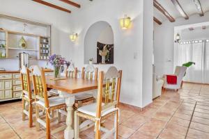 a kitchen and dining room with a wooden table and chairs at Casa Rural Prasat in Benirrama