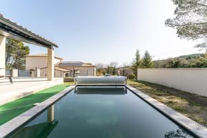 a pool with a bench next to a house at Villa Sérénity 10 pers maxi in Mondragon