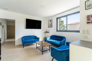 a living room with blue chairs and a table at Villa Sérénity 10 pers maxi in Mondragon