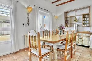 a kitchen and dining room with a wooden table and chairs at Casa Rural Prasat in Benirrama +24 photos