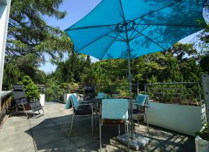 a table and chairs with a blue umbrella on a patio at Lichtdurchflutete Wohnung in Kempten
