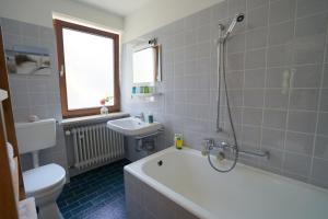 a bathroom with a tub and a toilet and a sink at Lichtdurchflutete Wohnung in Kempten +32 photos