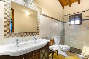 a bathroom with a sink and a toilet and a mirror at La Carrasca - Naranja in Catral +25 photos