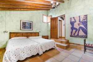 a bedroom with a bed and a painting on the wall at La Carrasca - Naranja in Catral