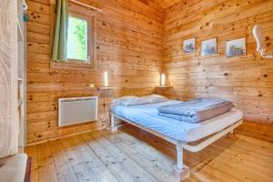 a bedroom with a bed in a wooden cabin at Chalet Rapiette in Salignac Eyvigues +31 photos