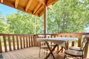 a porch with a table and chairs on a deck at Chalet Rapiette in Salignac Eyvigues