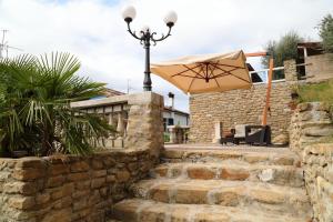 a street light with an umbrella on a stone wall at Re Piano appartamento Le Colline in Modigliana