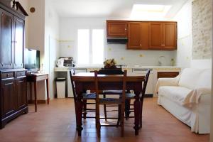 a kitchen with a table and a kitchen with a couch at Re Piano appartamento Le Colline in Modigliana