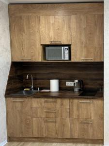 a kitchen with a sink and a microwave at Harmony Cottage in Kyiv