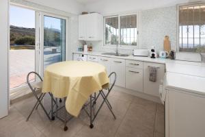 a kitchen with a table with a yellow table cloth on it at Finca Carrion in Periana