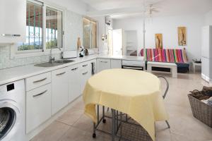 a kitchen with a sink and a table with a yellow stool at Finca Carrion in Periana