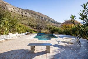 a swimming pool with two chairs and a bench at Finca Carrion in Periana
