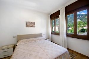 ein Schlafzimmer mit einem Bett und zwei Fenstern in der Unterkunft Chez Sabrina in Champdepraz