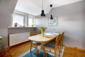 a dining room table with chairs and a vase of flowers at Ferienwohnung Nordmeer in Kappeln