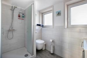 a white bathroom with a shower and a toilet at Ferienwohnung Nordmeer in Kappeln +14 photos