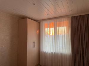 a room with a curtain and a cabinet and a window at Harmony Cottage in Kyiv +25 photos