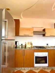 a kitchen with wooden cabinets and a white appliance at Tiri Hub in Tamraght Ouzdar +20 photos