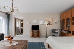 a living room with a bed and a television at Haus Gartenidylle in Wesselburen