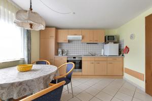 a kitchen with a table and chairs in a room at Haus Gartenidylle in Wesselburen