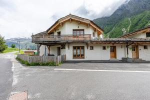 a house with a balcony on the side of a street at Gîte L'attrape Rêves in Bessans