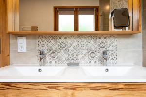 a bathroom with two sinks and a mirror at Gîte L'attrape Rêves in Bessans +25 photos