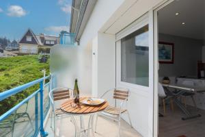 a patio with a table and chairs on a balcony at Appartement en front de mer in Plérin