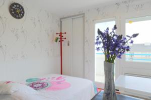 a room with a vase with purple flowers in it at Appartement en front de mer in Plérin