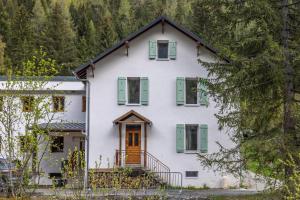 a white house with green shutters and a door at Chalet La Llyre Vallorcine in Vallorcine
