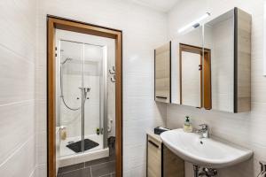 a white bathroom with a sink and a shower at Ferienwohnung Weitblick in Pottenstein +18 photos