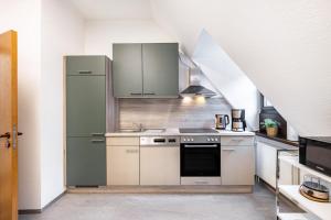 a kitchen with a refrigerator and a stove top oven at Ferienwohnung Weitblick in Pottenstein