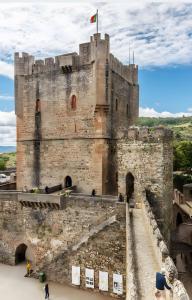 a castle with a flag on top of it at Origens - Alojamento Local in Bragança