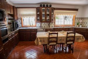 a kitchen with wooden cabinets and a table with chairs at Recanto Transmontano in Macedo de Cavaleiros