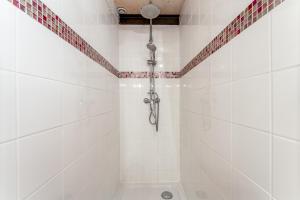 a bathroom with a shower with white tiles at Chambre Laurier Rose in Piolenc