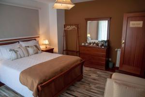 a bedroom with a bed and a dresser and a mirror at Recanto Transmontano in Macedo de Cavaleiros +31 photos