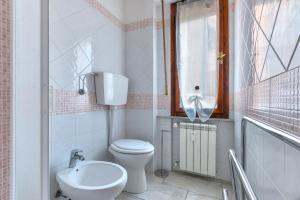 a bathroom with a toilet and a sink and a window at Casa Claudia a Porto Azzurro in Porto Azzurro +12 photos
