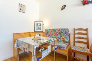 a living room with a table and a chair at Studio Turquoise à 100m de la plage in Bénodet