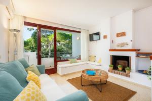 a living room with a blue couch and a fireplace at Ferrera Suite in Cala Ferrera