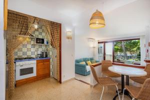 a kitchen and a living room with a table and a dining room at Ferrera Suite in Cala Ferrera