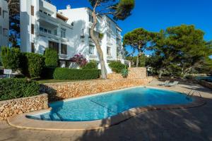 a swimming pool in front of a building at Ferrera Suite in Cala Ferrera