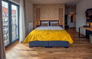 a bedroom with a large bed with a yellow blanket at Residency NO7 in Berlin