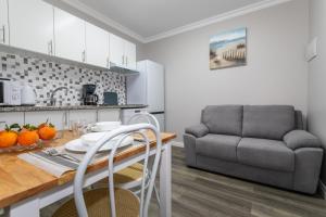 a kitchen and living room with a table and a couch at Oásis Fonte Grande in Santo António