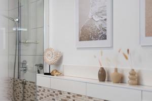 a bathroom with a shower with a shelf and vases at Ferienwohnung Mayer in Albstadt +22 photos