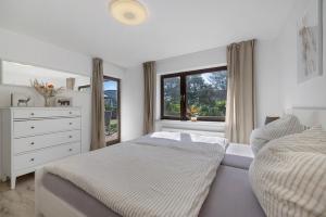 a bedroom with two beds and a dresser and a window at Ferienwohnung Mayer in Albstadt