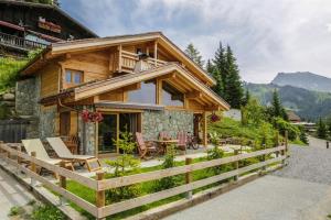 a log cabin with a table and chairs in front of it at Chalet Pesse in Manigod