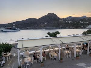 a restaurant with a view of the water and a boat at Emma's maisonette house by Kapsali beach in Kapsali