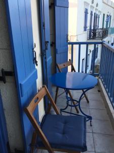 a blue table and a chair on a balcony at Emma's maisonette house by Kapsali beach in Kapsali +40 photos